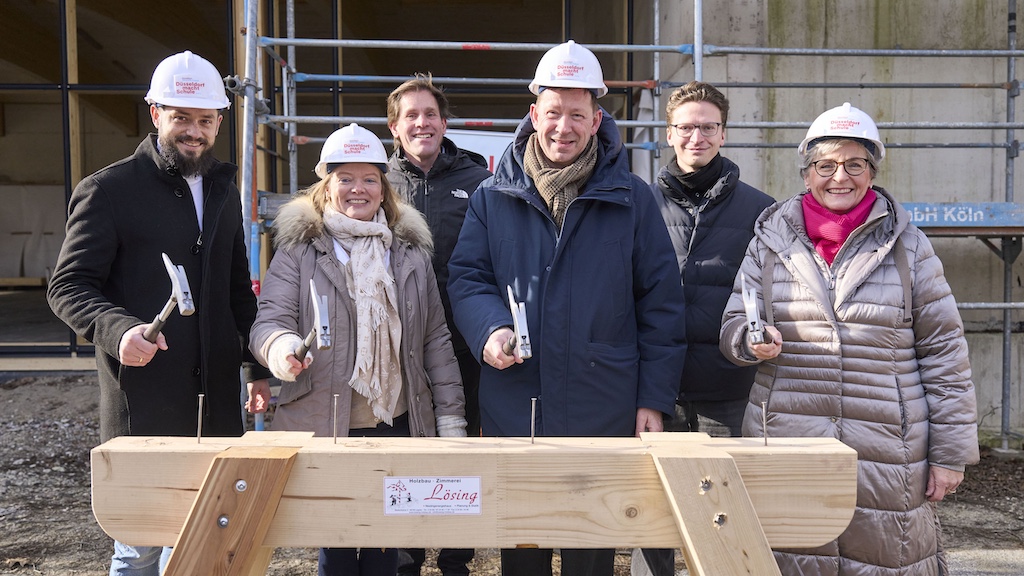 Beim Richtfest (v.r.): Dagmar Wandt, Leiterin des Amtes für Schulen und Bildung, Simon Bauer, hks architekten, Stadtdirektor Burkhard Hintzsche, Bezirksbürgermeister Philipp Schlee, Schulleiterin Andrea Knopper und Sebastian Schimanski, OGS-Leitung,(c)Landeshauptstadt Düsseldorf/Claus Langer