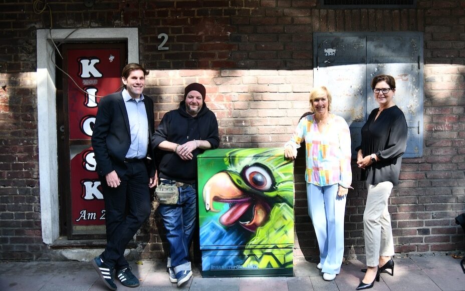 Philipp Schlee, Alexander Weuffen, Elke Böttcher und Heidrun Leinenbach (v.l.) mit dem zweiten Motiv am Zoo-Pavillon. © Lokalbüro