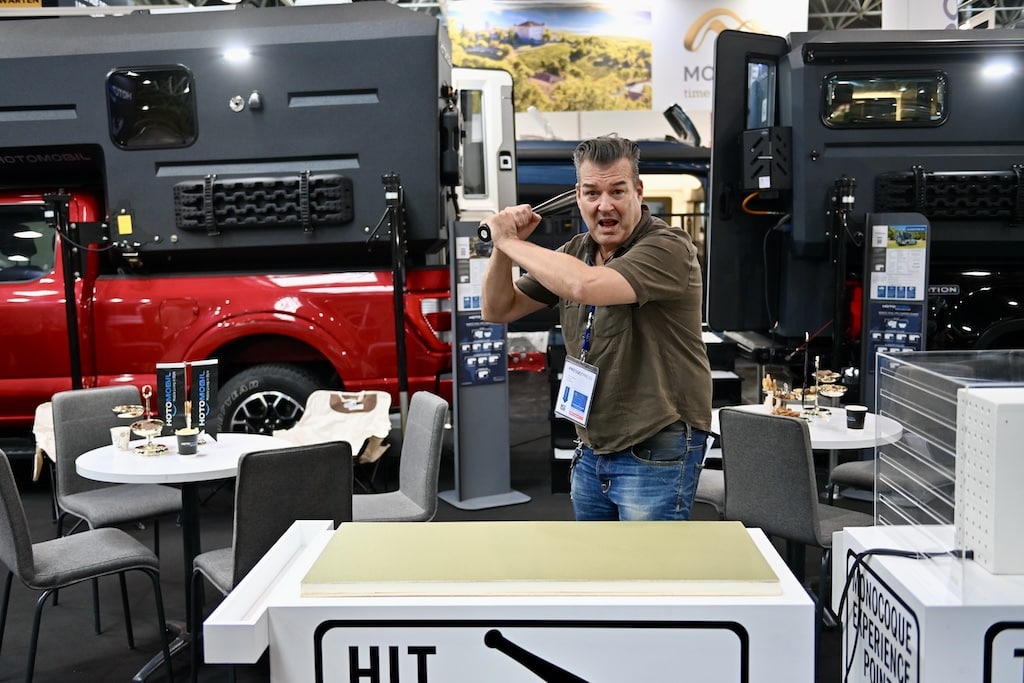 Mit einem Baseballschläger kann eine Demoplatte des Verbundstoffes bearbeitet werden. © Lokalbüro