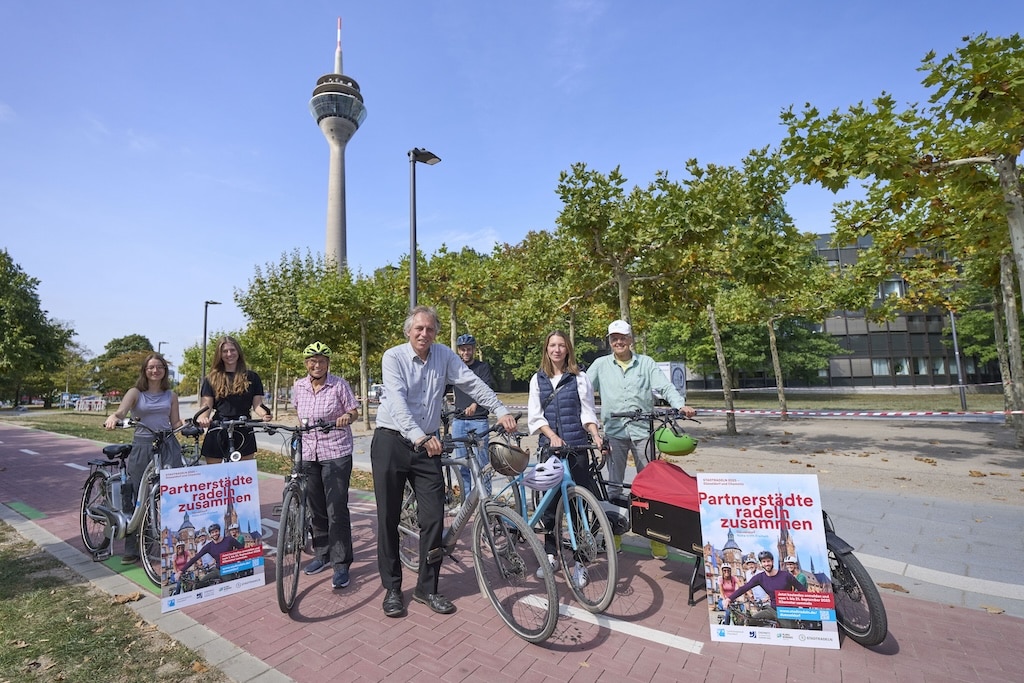 Jochen Kral (M.), Dezernent für Mobilität und Umwelt, und Mitarbeiter der Stadt präsentieren das Stadtradeln-Plakat.© Landeshauptstadt Düsseldorf/Claus Langer
