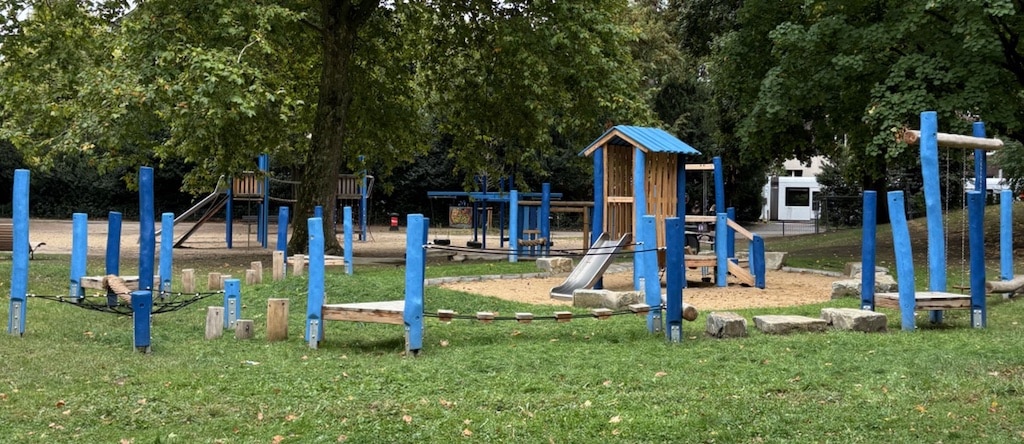 Der erneuerte Spielplatz im Hanielpark bietet nun auch den jüngeren Kindern die Möglichkeit, sich auf einer kleineren Rutsche, im Spielhaus oder auf dem Podest mit seinen Sandspielelementen zu vergnügen. © Landespautstadt Düsseldorf / Gatenamt