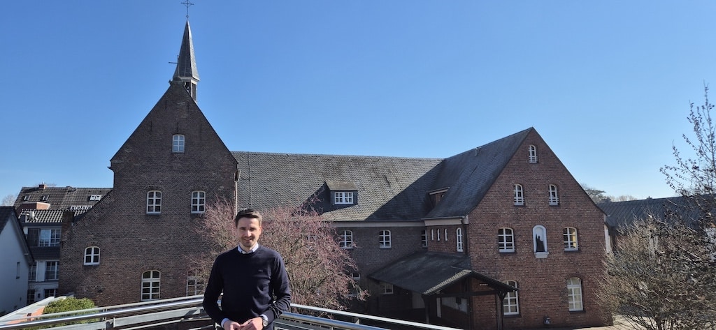 Christian Schwingeler im Hintergrund das alte Kloster des Erzbischöflichen St. Suitbertus Gymnasiums © Gabriele Schreckenberg