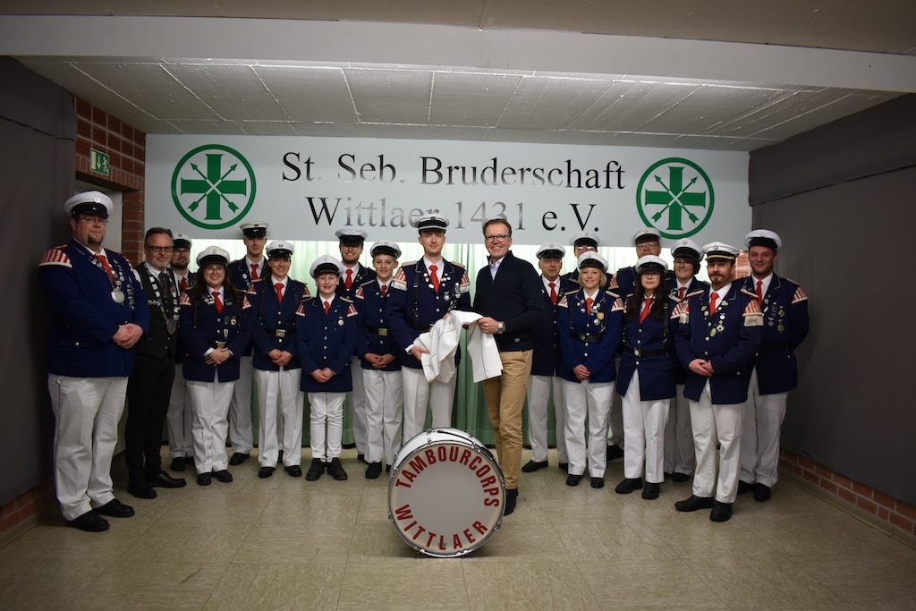 Dominic Schlarmann, Vorstand der Sparda-Bank West, übergibt die Spende an den Mayor des Tambourcorps Niclas Busch Foto: Privat