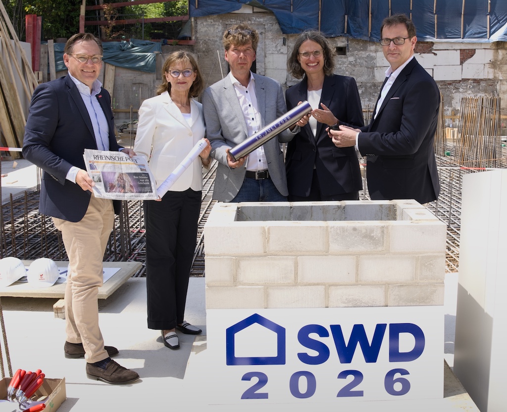 Grundsteinlegung Wilhelm-Kreis-Straße 3, Gruppenbild mit Zeitkapsel, von links nach rechts: Victor von Detmering (Geschäftsführer domoplan Baugesellschaft mbH), Dr. Eva-Maria Illigen-Günther (Geschäftsführerin SWD), Klaus Feldhaus (Geschäftsführer SWD), Dr. Friederike Nesselrode (Leiterin des Amtes für Wohnungswesen der Landeshauptstadt Düsseldorf) und Julien Mounier (Vorstandvorsitzender der Stadtwerke Düsseldorf); Copyright SWD, Fotograf Bernd Schaller