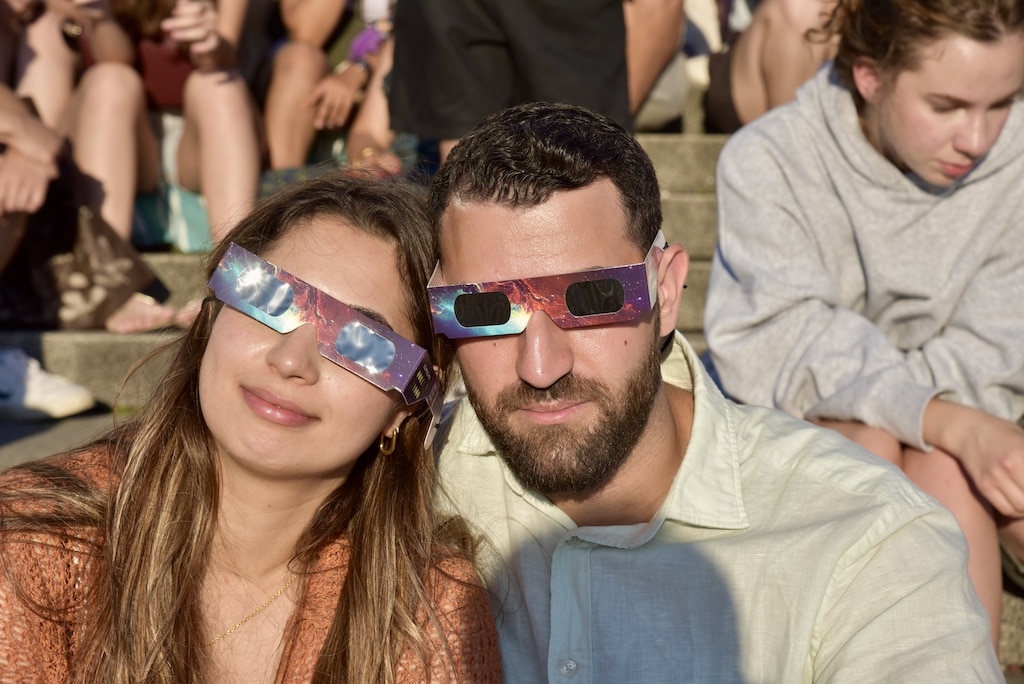 Mit Spezialbrille bestens gerüstet: Ein Pärchen verfolgt auf der Burgplatztreppe gemeinsam mit vielen anderen Besuchern die Sonnenfinsternis über Düsseldorf. © Lokalbüro