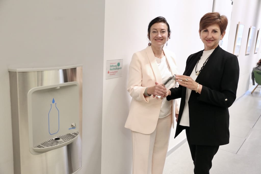 Beigeordnete Miriam Koch (l.) und Frau Tatiana Helfrich, Geschäftsführerin der Stiftung Nachhaltigkeit der Stadtsparkasse Düsseldorf, testeten den neuen Wasserspender in der Zentralbibliothek im KAP1. © Landeshauptstadt Düsseldorf/Ingo Lammert