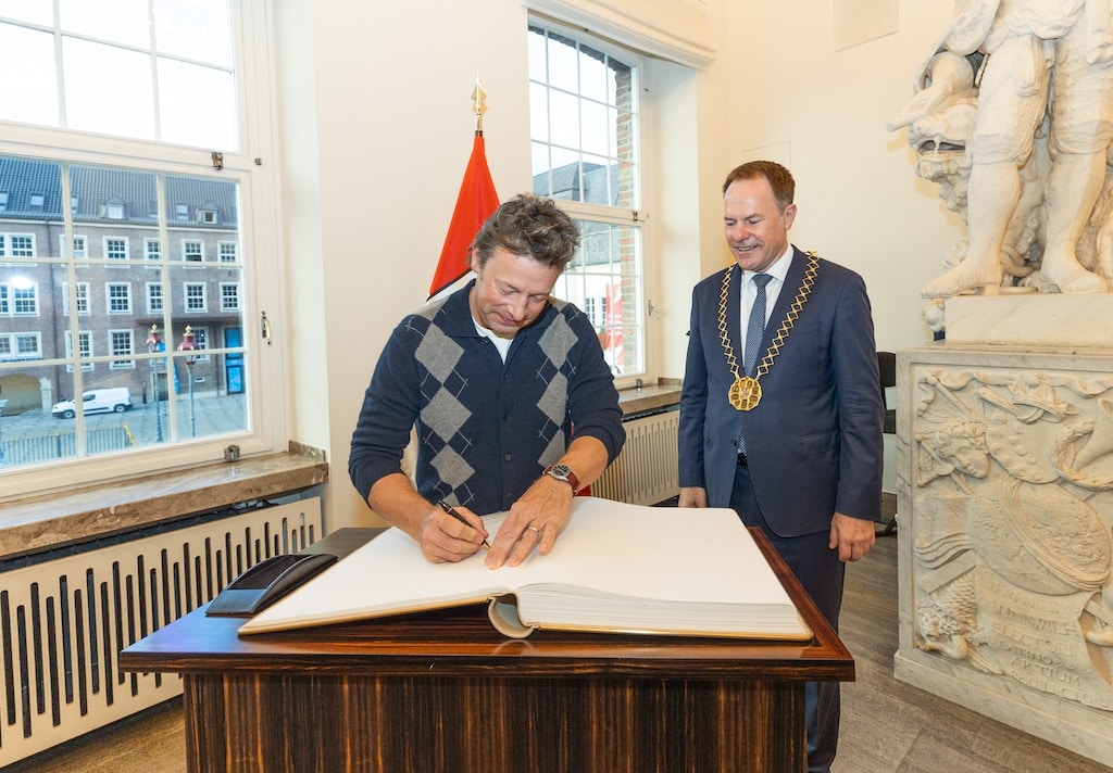 Der weltbekannte britische Fernsehkoch, Kochbuchautor und Gastronom Jamie Oliver besuchte am Mittwoch, 30. September 2026, das Düsseldorfer Rathaus und wurde von Oberbürgermeister Dr. Stephan Keller im Jan-Wellem-Saal begrüßt. Dabei trug er sich in das Goldene Buch der Landeshauptstadt ein. © Landeshauptstadt Düsseldorf/Melanie Zanin