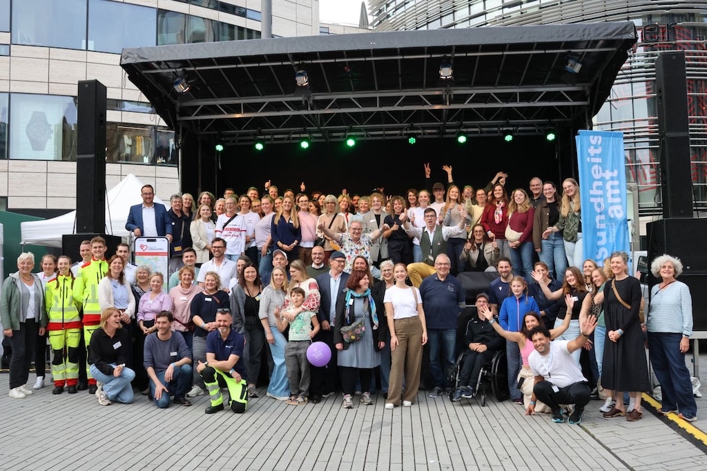 Organisatoren, Rettungskräfte und Akteure des Gesundheitstags 2026 versammelten sich zum Abschluss auf der Bühne am Schadowplatz.