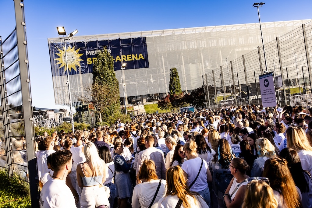 Dichtes Gedränge vor der Merkur Spiel-Arena: Die Fans, viele in Weiß, warteten am Einlass auf den Zugang zu Golden Circle und Stehplatz Innenraum.