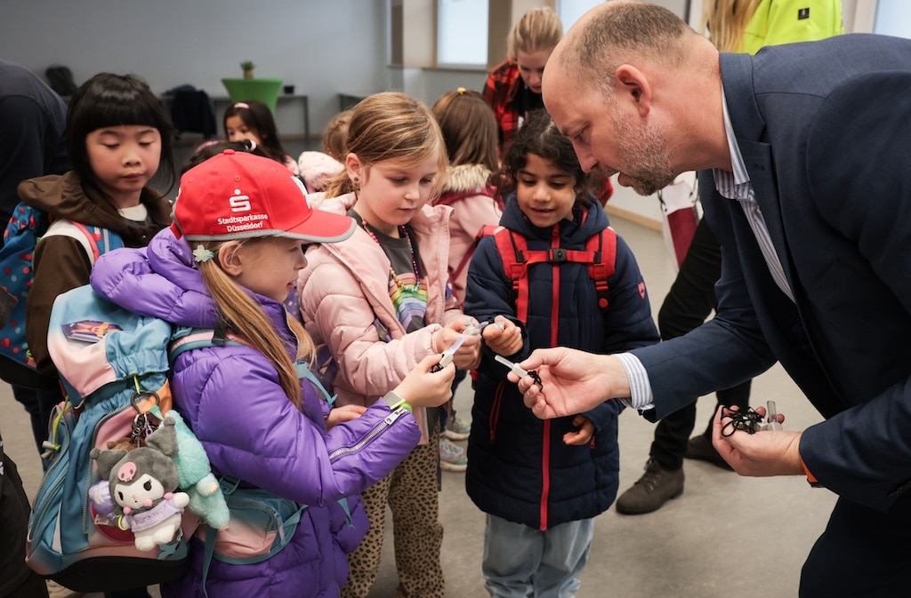 Beigeordneter Marcus Beyer (rechts) verteilt die Blinkis an die Kinder der Regenbogenschule. © Landeshauptstadt Düsseldorf/Melanie Zanin